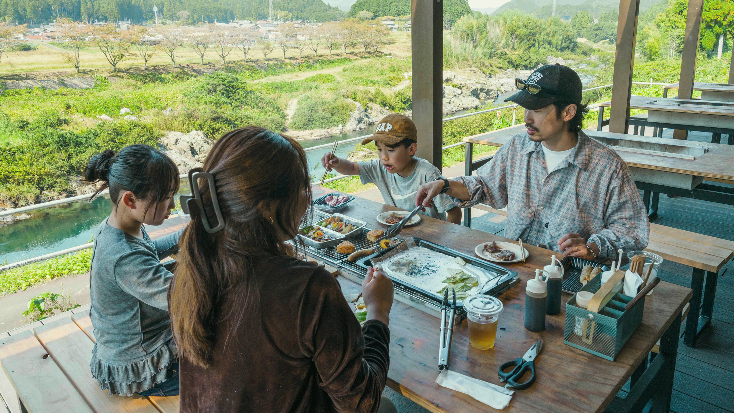 長良川沿いの屋根付き席で食事をする人たち