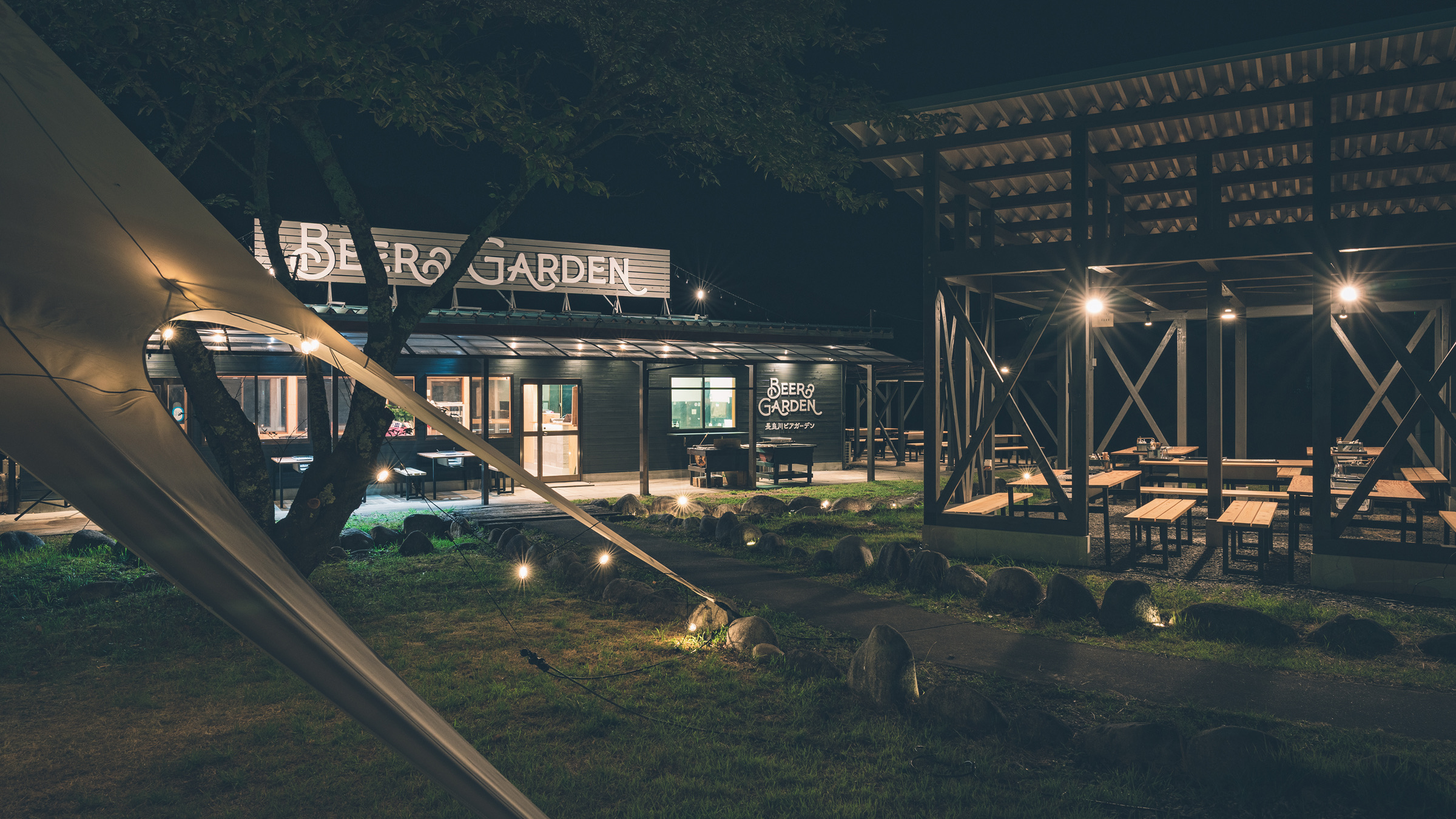 夜の長良川ビアガーデン外観。屋根下の席と建物に明かりが灯っている