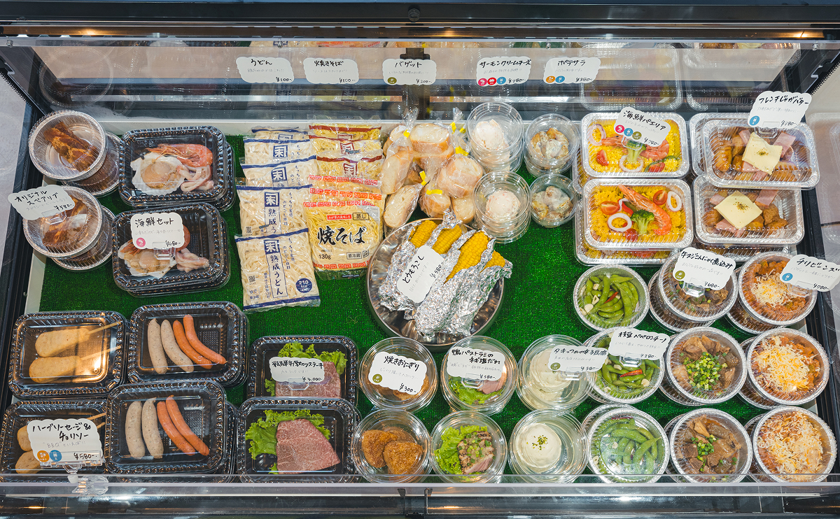 売り場の冷蔵ケースに並ぶ惣菜や麺、ソーセージ