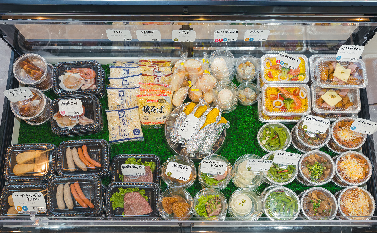 売り場の冷蔵ケースに並ぶ惣菜や野菜、デザート